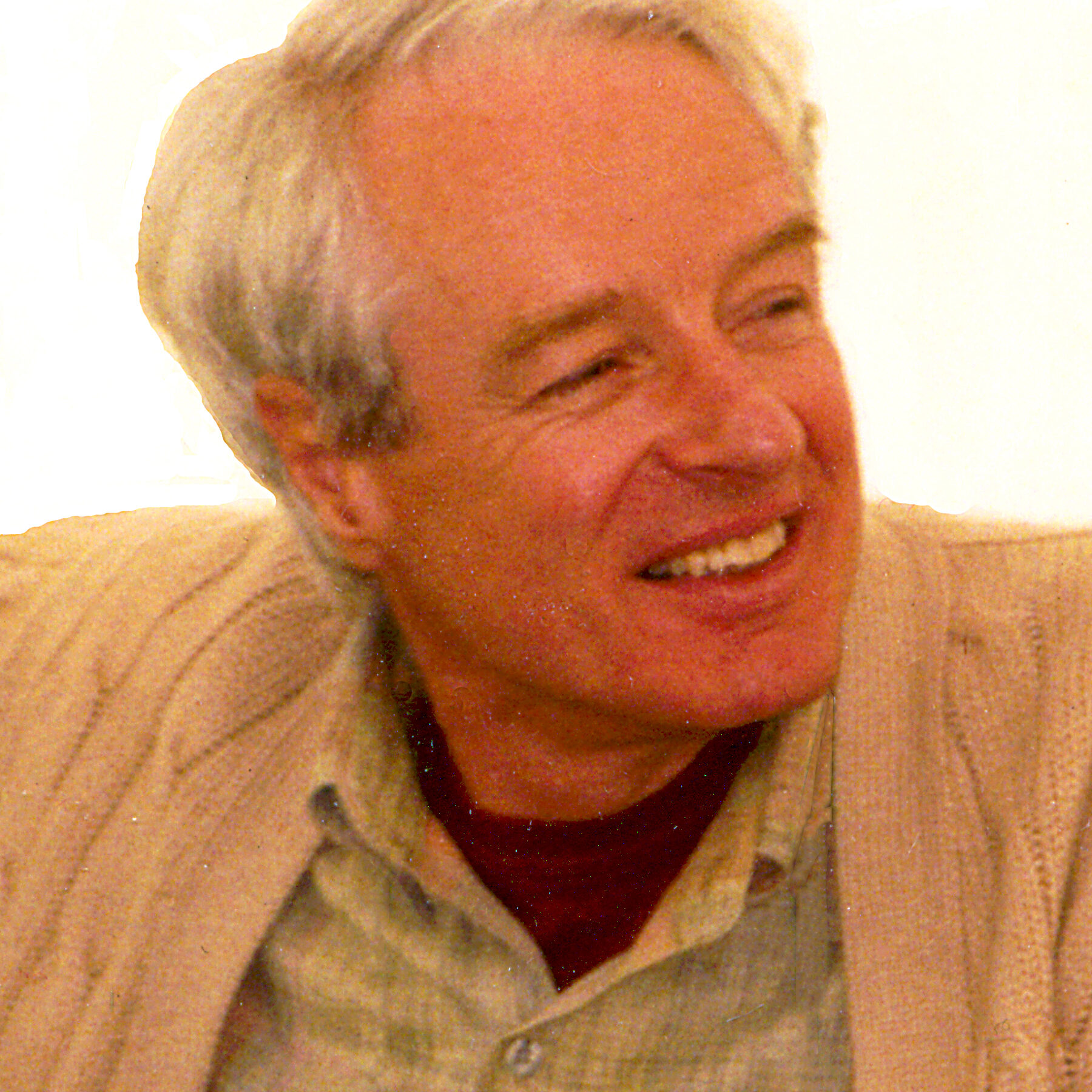 Headshot image of Adam Hochschild smiling and wearing neutral tones.