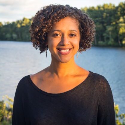 Sarah Childress headshot, Sarah is standing in front of a body of water wearing a black top.