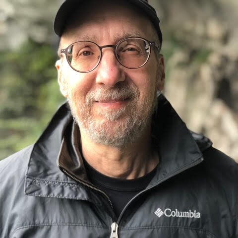 Stecklow headshot Steve Stecklow looks directly at the camera, wearing a black rainshell and black baseball cap.